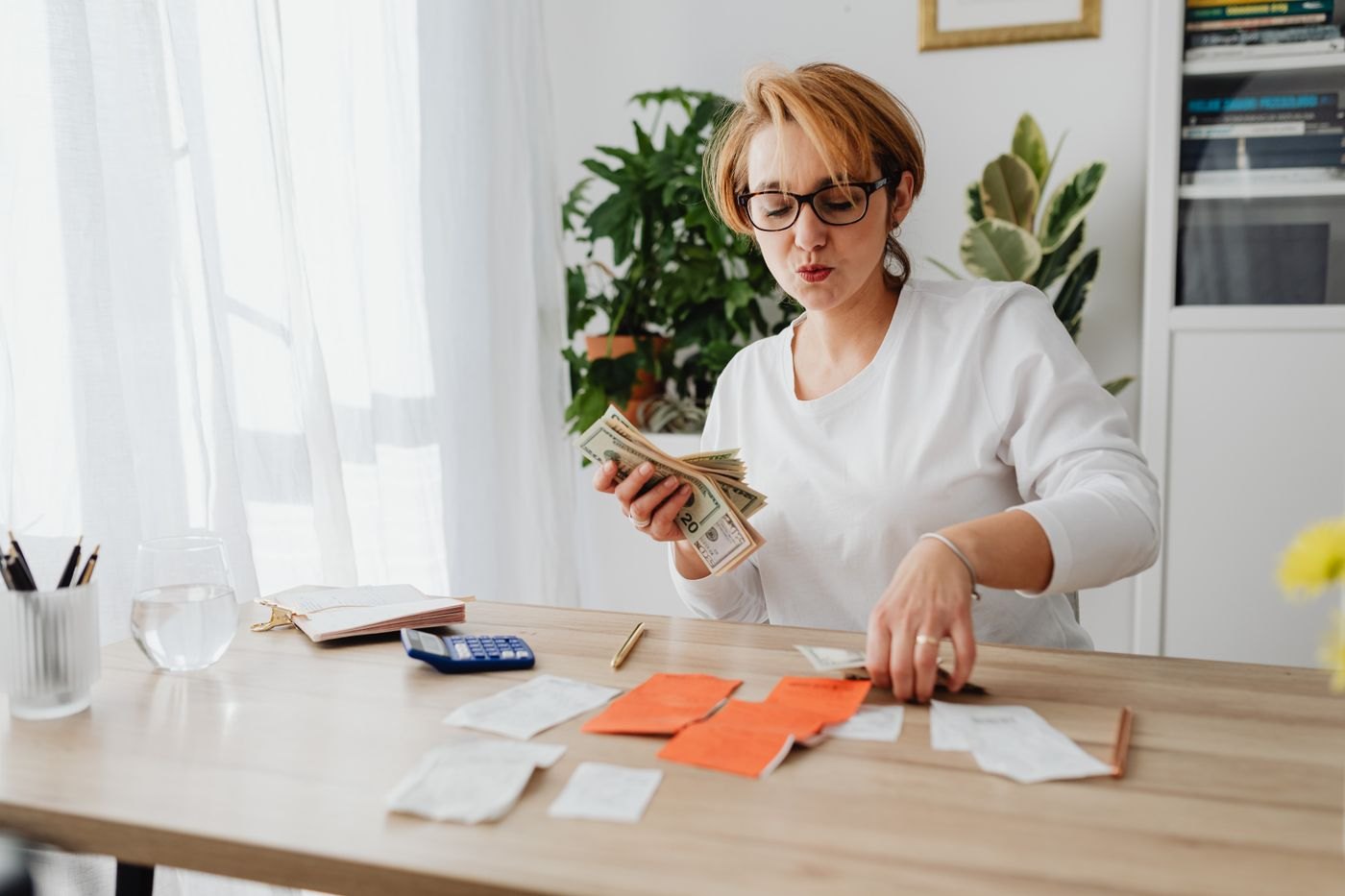 A person organising cash and receipts at a table