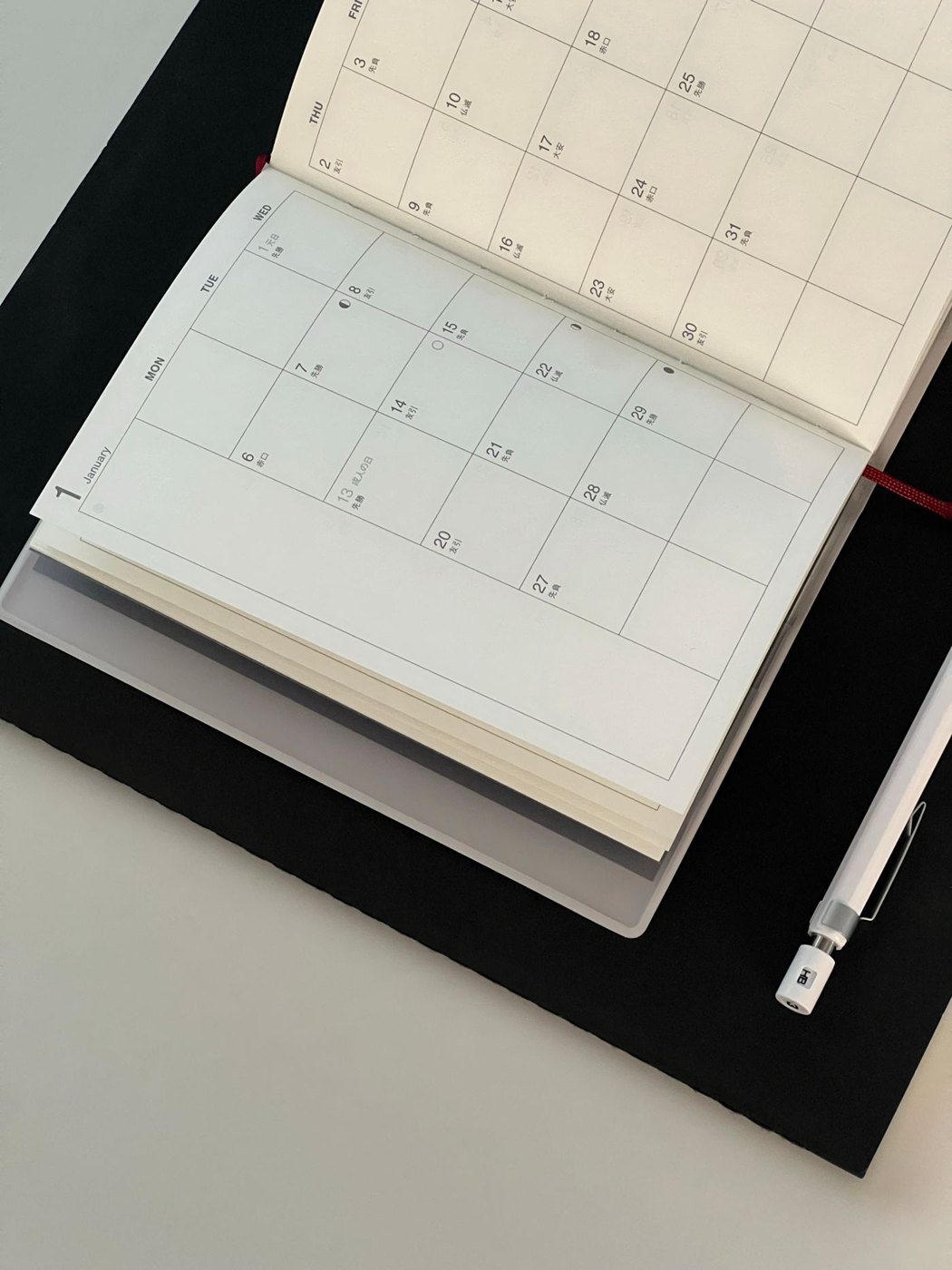 An open dated planner beside a pen