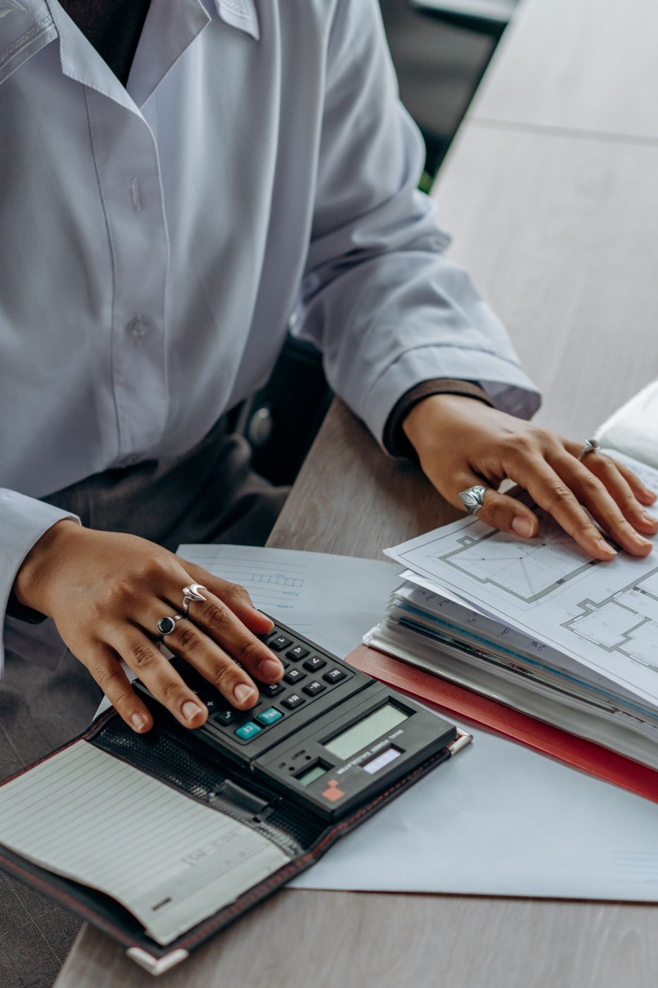 A person reviewing documents with a calculator