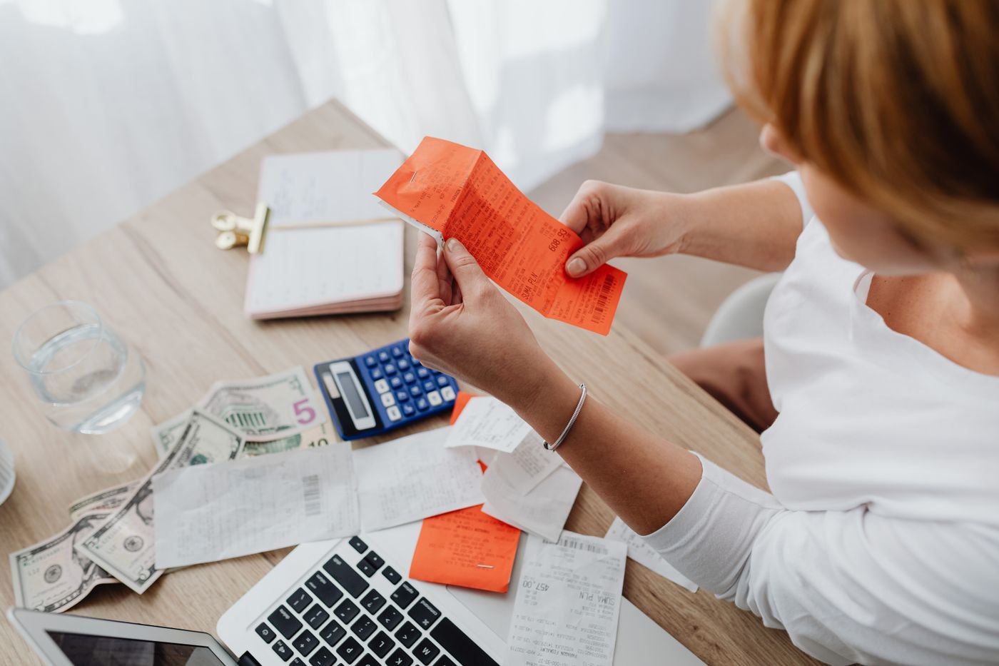 A person sorting envelopes and receipts at a desk