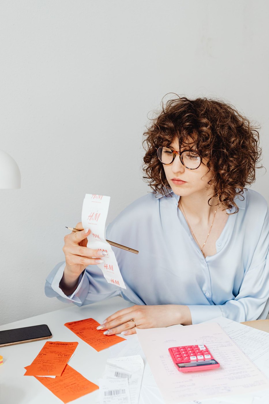 A person reading a receipt with financial papers