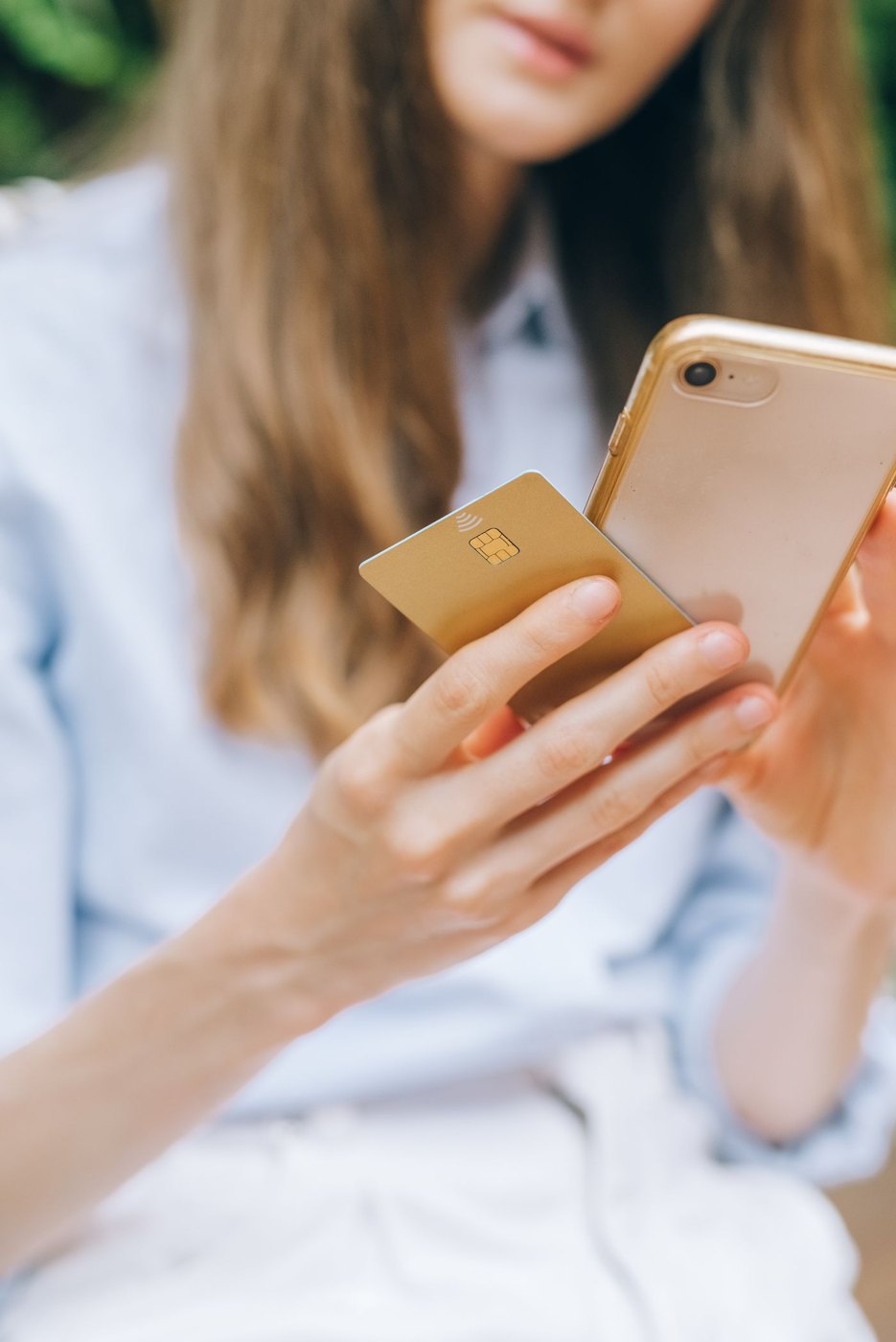 A person using a phone beside a bank card