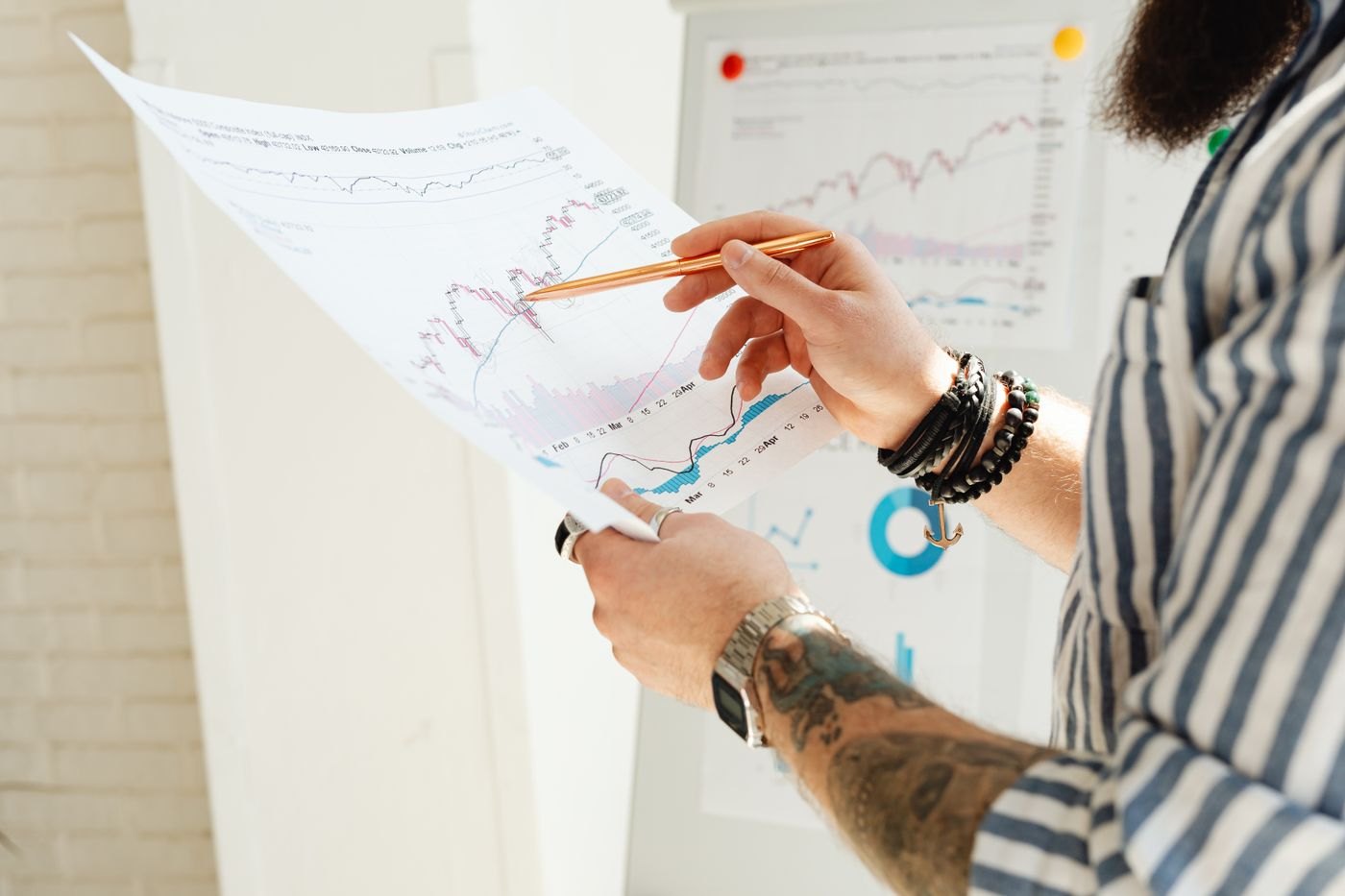 A hand tracing a line on a printed market chart