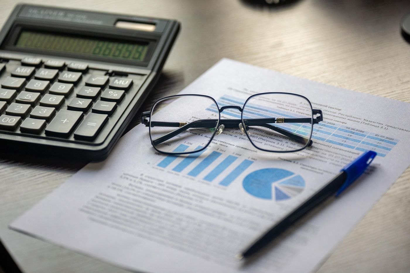 A financial document alongside a calculator and glasses
