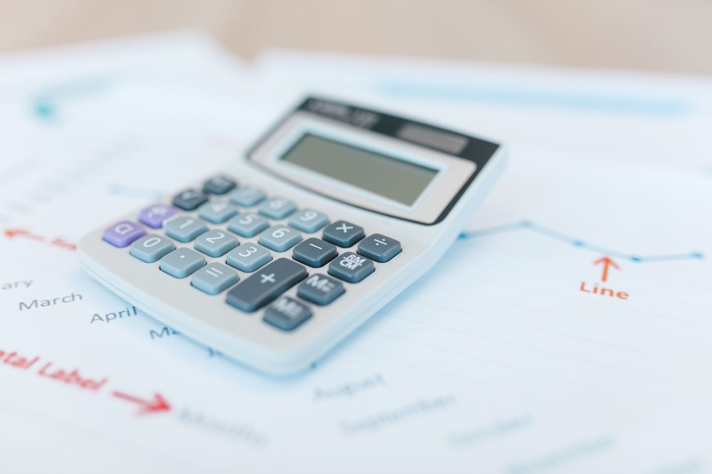 A calculator placed on printed financial figures