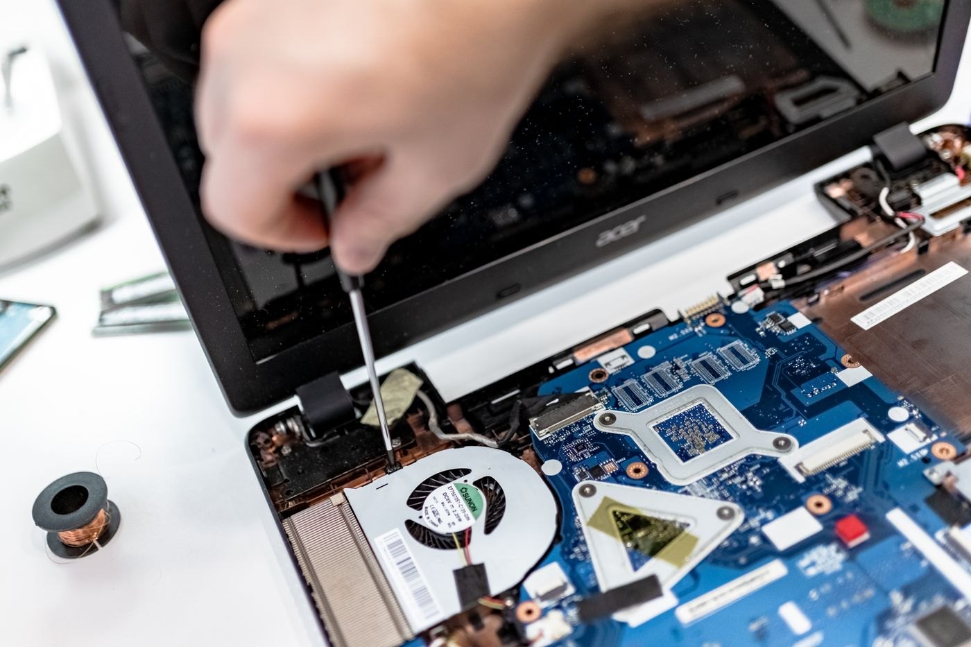 A person inspecting the inside of a laptop
