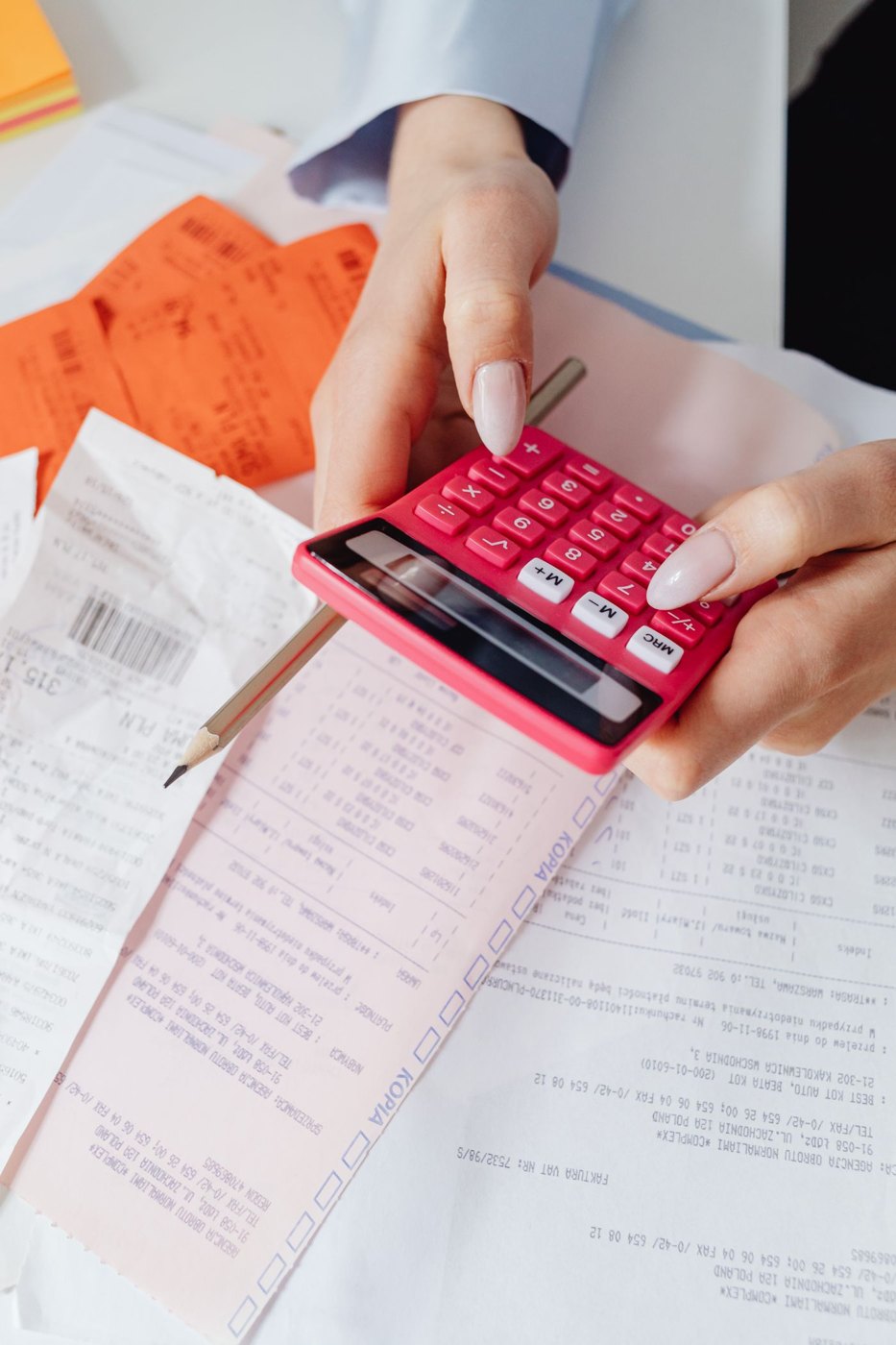 A person reviewing receipts with a calculator